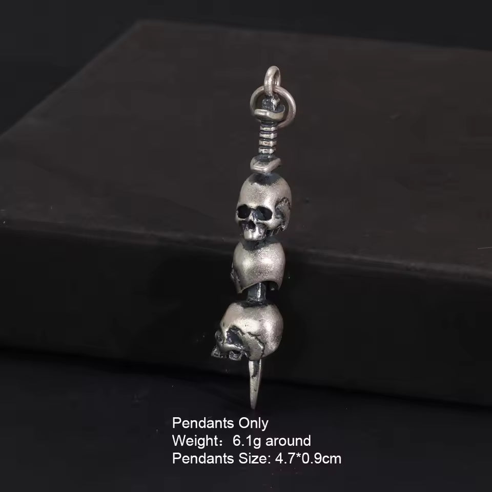 3 skulls on a sword Pendant detail on dark background