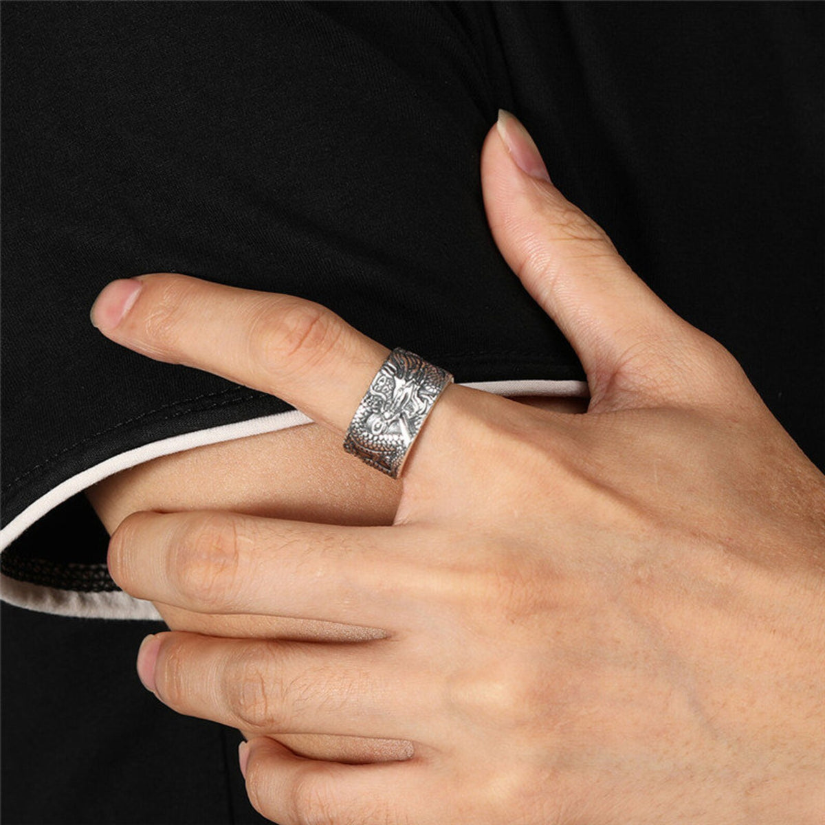 Adjustable 990 fine silver dragon ring with Heart Sutra engraving worn on a finger, close up view