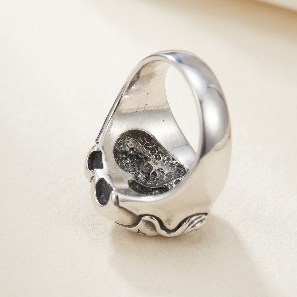 Angled view showing the back profile and hollow heart-shaped interior construction of the sterling silver ring on a light background