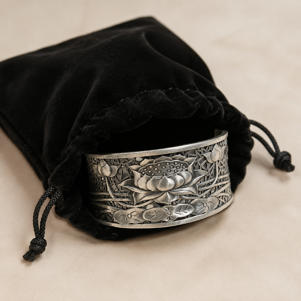 Antique finish silver cuff with raised lotus flower design inside velvet black gift bag