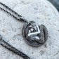 Antiqued 925 silver mermaid pendant displayed on dark textured rock