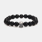 Black natural stone bead bracelet with centered sterling silver skull bead, front view