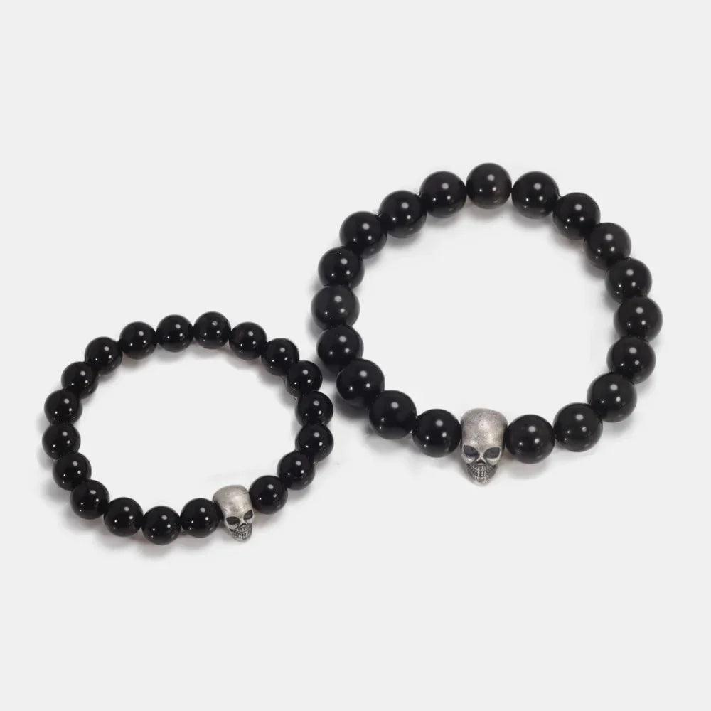 Black stone bead bracelet with sterling silver skull bead, shown in two sizes