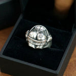 Close-up shot of a 925 sterling silver "Kiss My Ass" sculpted butt ring inside a black velvet-lined gift box