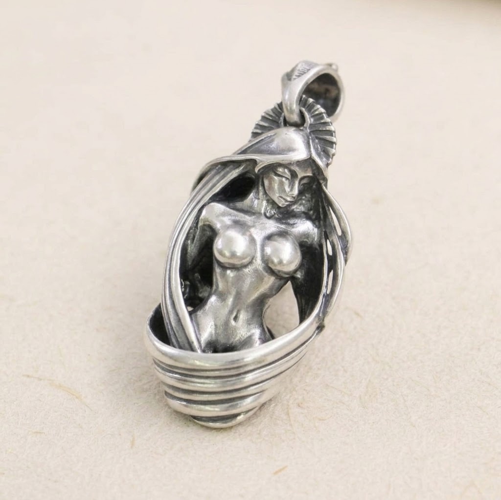 Front view of solid 925 sterling silver nude goddess pendant on light background