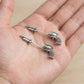 Hand holding pair of 925 silver pistol jacket earrings