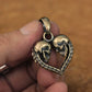 Handcrafted brass skull heart pendant shown on hand