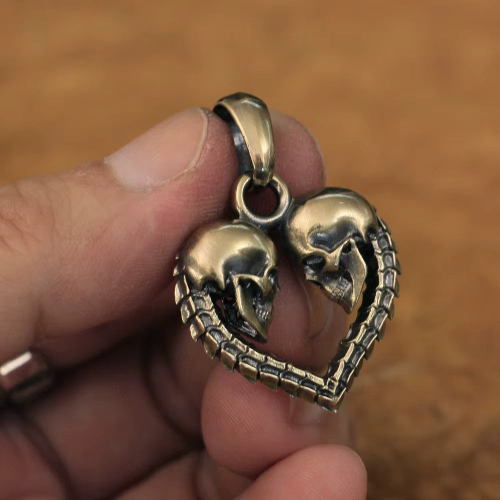 Handcrafted brass skull heart pendant shown on hand