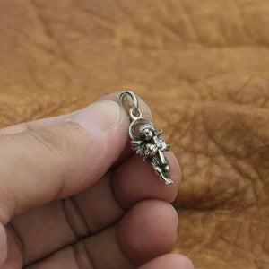 Handcrafted sterling silver angel pendant shown on hand