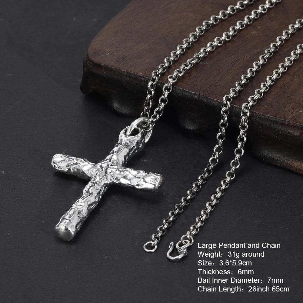Large textured silver cross pendant necklace with chain displayed on a dark surface