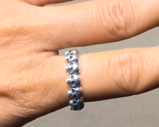 Silver skull statement ring on finger