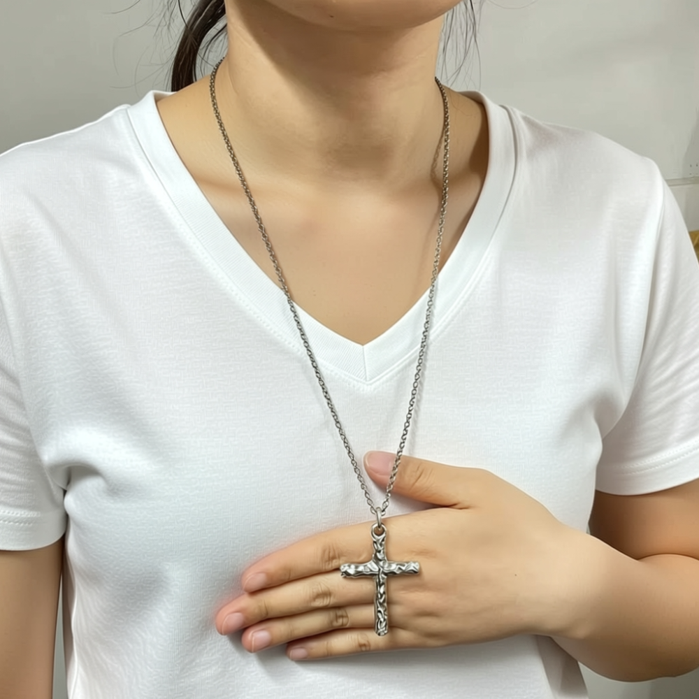 Sterling silver cross necklace worn at chest length