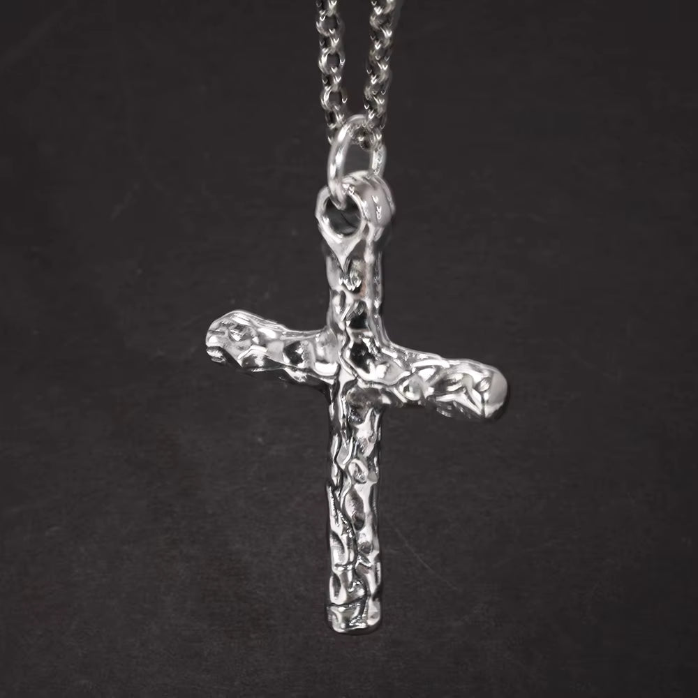 Sterling silver cross pendant hanging from a chain, front view