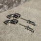 Two piece silver gun studs separated on neutral background