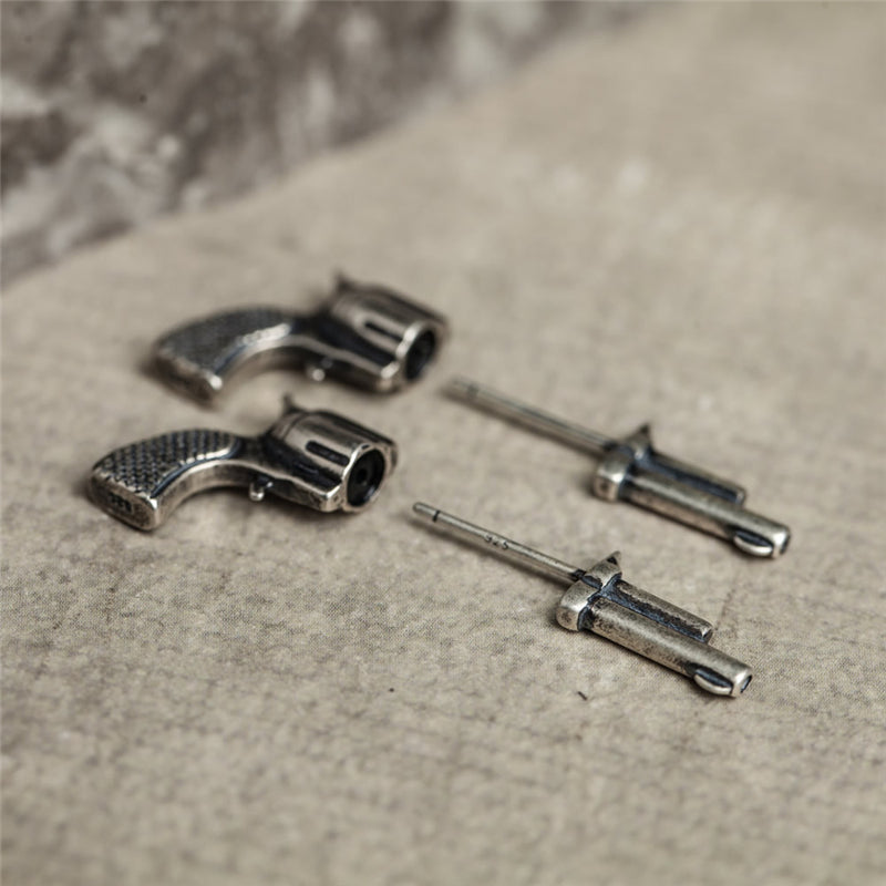 Two piece silver gun studs separated on neutral background