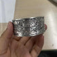 Woman holding a 999 silver lotus bangle in her hand