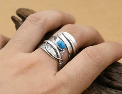 feather design silver ring on a finger