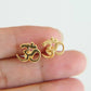 gold plated om symbol studs held in hand detailed view