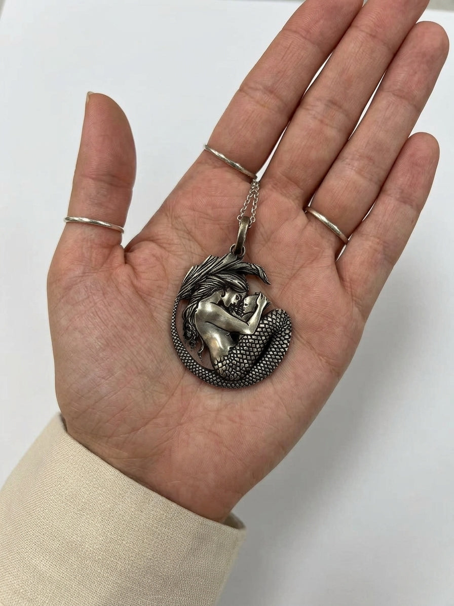 handcrafted sterling silver mermaid pendant on model hand