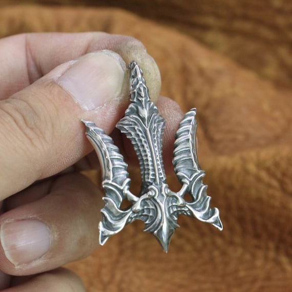 handcrafted trident pendant texture