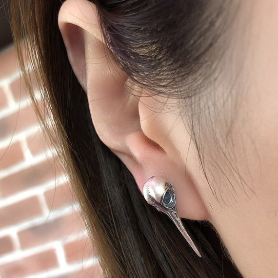 hummingbird skull earrings worn on ear