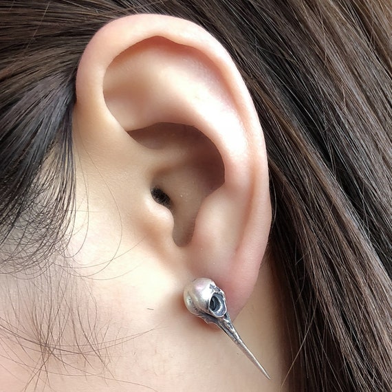 hummingbird skull stud earrings on ear