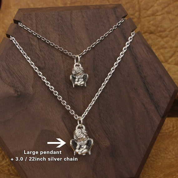 large silver cherub pendant paired with 22 inch silver chain