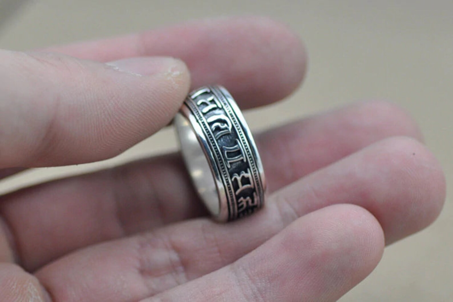 meditation spinning ring shown in hand for engraved details