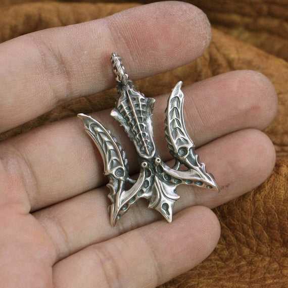 mythology trident pendant close up on hand