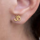 om stud earrings in gold on ear