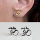 om symbol stud earrings on ear close up