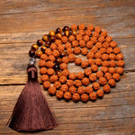 rudraksha and tiger eye mala displayed on wood