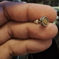 silver gold om stud earring on hand