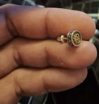 silver gold om stud earring on hand